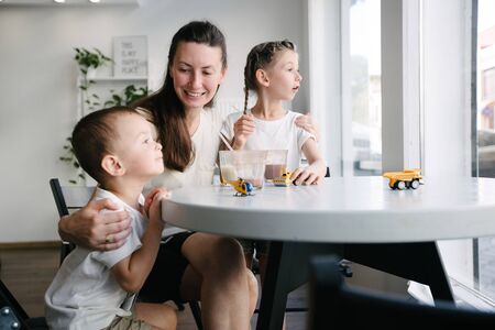 Mother with children drinking hot chocolate and latte at a local coffee shop. They are smiling and having fun. Motherhood conceptの写真素材