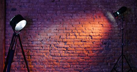 Old retro red brick wall being lit by a stage light bulb light. Constant light modifier projecting light on itの写真素材