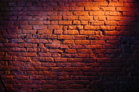 Old retro red brick wall being lit by a stage light bulb light. Constant light modifier projecting light on itの写真素材