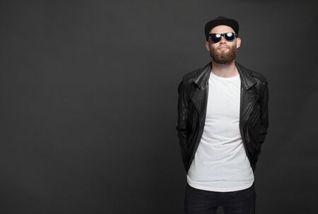 Hipster handsome male model with beard wearing white blank t-shirt and a baseball cap with space for your logo or design in casual urban styleの写真素材