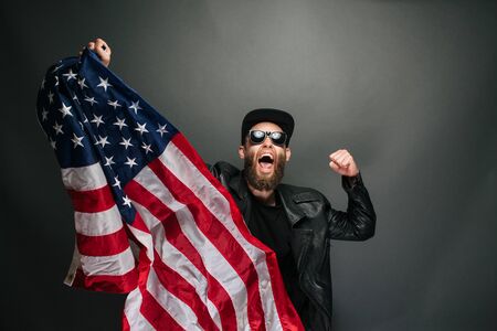 Patriot hipster man holding emotionally american USA flagの写真素材