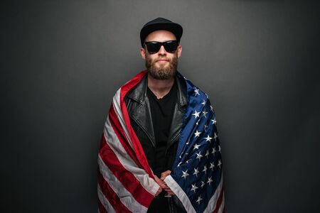 Patriot hipster man holding emotionally american USA flagの写真素材