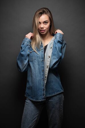 Sexy blonde girl wearing jeans clothes over gray backgroundの写真素材