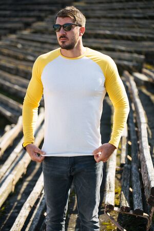 Hipster handsome male model with beard wearing white blank t-shirt and a baseball cap with space for your   design in casual urban styleの写真素材