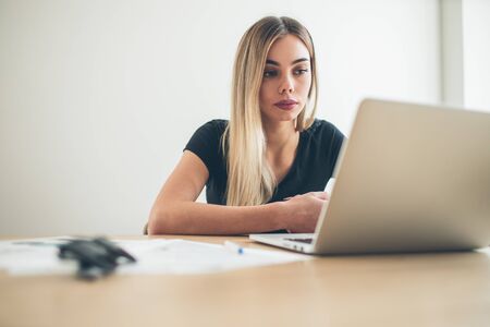 Pretty business freelancer woman working on her computer. Girl at her workspace. Start-up office...
