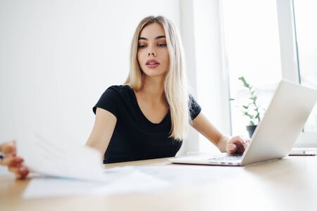 Pretty business freelancer woman working on her computer. Girl at her workspace. Start-up office backgroundの写真素材