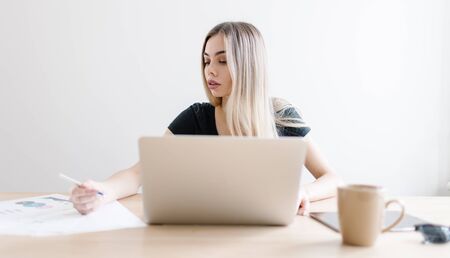 Pretty business freelancer woman working on her computer. Girl at her workspace. Start-up office backgroundの写真素材