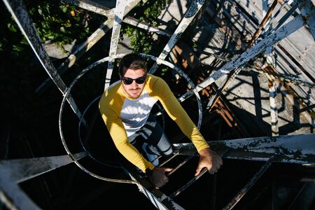 Portrait of a Hipster man with the beard close up climbing a metal ladder