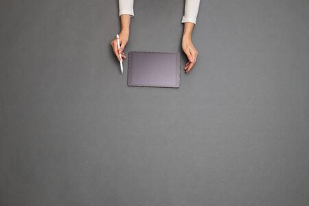 Woman holding a tablet PC. Overhead imageの写真素材