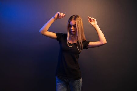 Sexy young blonde girl portrait over gray paper background in neon lightsの写真素材