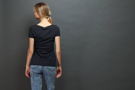 Sexy woman or girl wearing black blank t-shirt with space for your  mock up or design in casual urban style over gray backgroundの写真素材