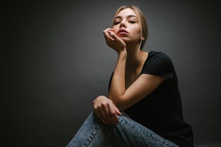 Fashion portrait of a sexy blonde woman with a make up wearing black clothesの写真素材