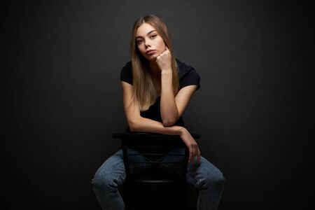 Fashion portrait of a sexy blonde woman with a make up wearing black clothes