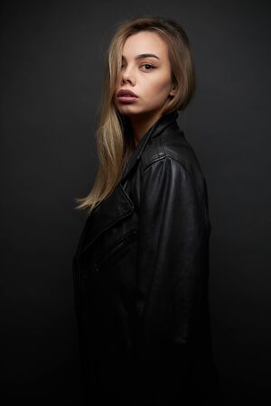 Fashion portrait of a sexy blonde woman with a make up wearing black clothesの写真素材