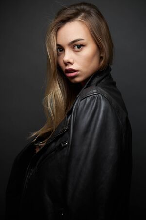 Fashion portrait of a sexy blonde woman with a make up wearing black clothesの写真素材