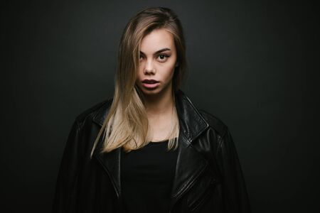 Fashion portrait of a sexy blonde woman with a make up wearing black clothesの写真素材