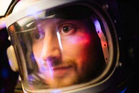 Astrounaut man in a helmet looking ahead exploring the earth in a darkの写真素材