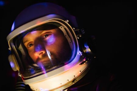 Astrounaut man in a helmet looking ahead exploring the earth in a darkの写真素材