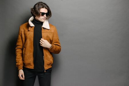 Man wearing orange coat over gray textureの写真素材