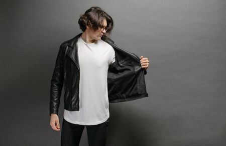 Hipster handsome male model with glasses wearing white blank t-shirt and black jeans with space for your logo or design in casual urban styleの写真素材