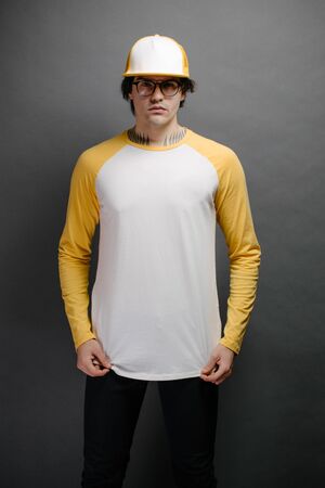 Man model with beard wearing white and yellow blank Long Sleeve Shirt for mock up and a baseball cap with space for your designの写真素材