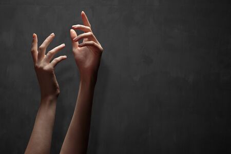 Hand reaching for the sky or for God over darkの写真素材