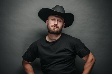 Handsome cowboy wearing black cowboy hat with beardの写真素材
