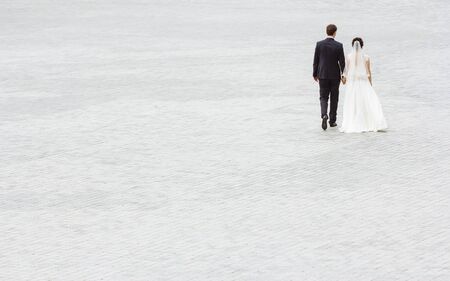 Wedding couple walking away. Empty with space for textの写真素材