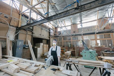 Confident woman working as carpenter in her own woodshop. Carpentry interiorの写真素材