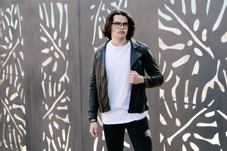 Hipster handsome male model wearing white blank t-shirt with space for your logo or design in casual urban styleの写真素材