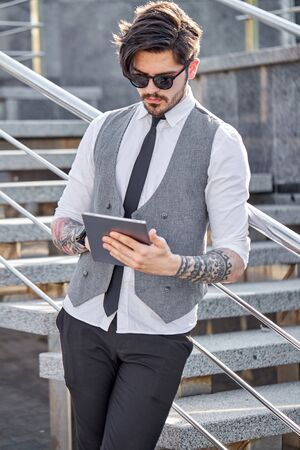 Young Businessman using a tablet pc outside wearing a classic suitの写真素材