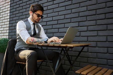 Young handsome man sitting and working on laptopの写真素材
