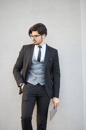 Young Businessman using a tablet pc outside wearing a classic suitの写真素材