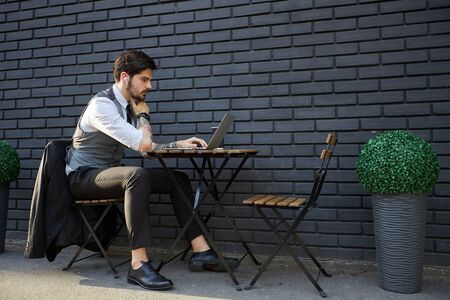 Young handsome man sitting and working on laptopの写真素材