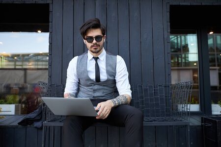 Young handsome man sitting and working on laptopの写真素材