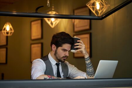Young handsome man sitting and working on laptopの写真素材