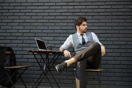 Young handsome man sitting and working on laptopの写真素材