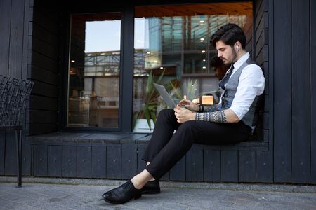 Young handsome man sitting and working on laptopの写真素材