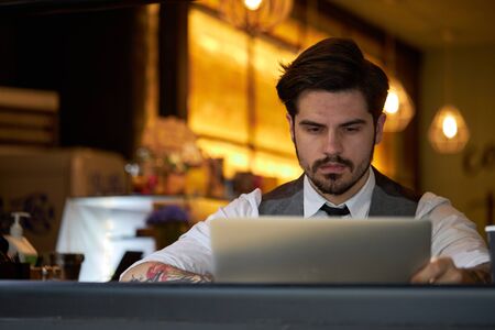 Young handsome man sitting and working on laptopの写真素材