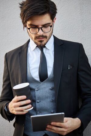 Young Businessman using a tablet pc outside wearing a classic suitの写真素材