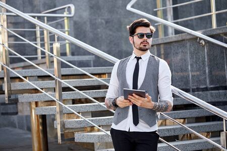 Young Businessman using a tablet pc outside wearing a classic suitの写真素材