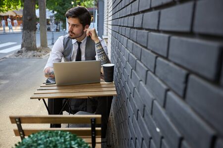 Young handsome man sitting and working on laptopの写真素材