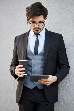 Young Businessman using a tablet pc outside wearing a classic suitの写真素材