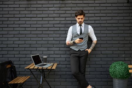 Handsome businessman making a phone call or using a phone outsideの写真素材