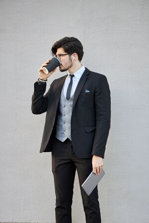 Young Businessman using a tablet pc outside wearing a classic suitの写真素材