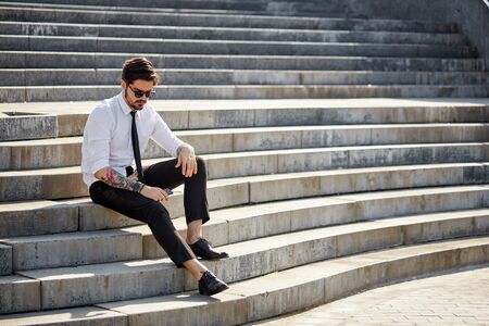 Handsome businessman making a phone call or using a phone outsideの写真素材