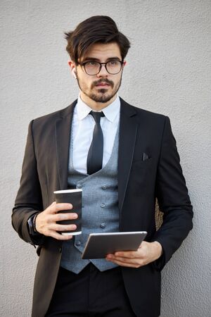 Young Businessman using a tablet pc outside wearing a classic suitの写真素材