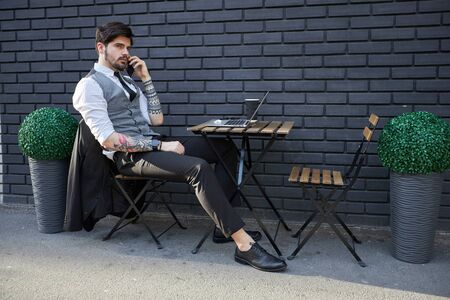 Handsome businessman making a phone call or using a phone outsideの写真素材