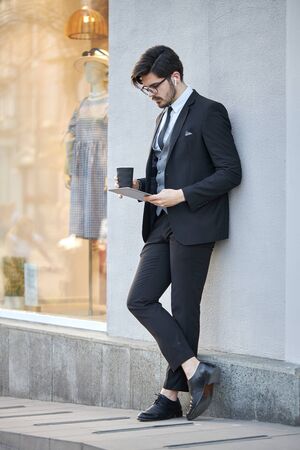 Young Businessman using a tablet pc outside wearing a classic suitの写真素材