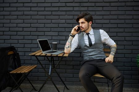 Young handsome man sitting and working on laptopの写真素材